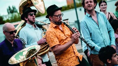 Die Brassband Banda Comunale spielt, zu sehen sind Menschen, die verschiedene Instrumente spielen. 