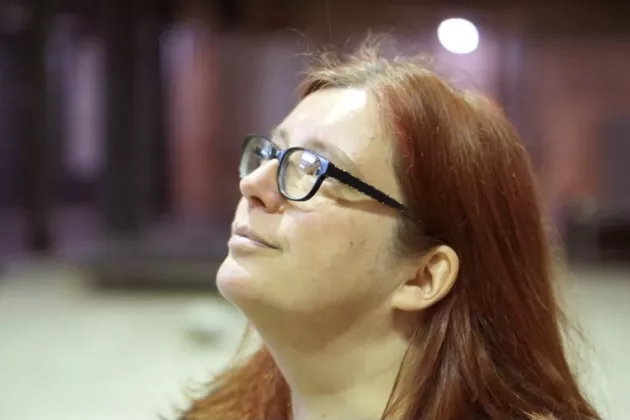 Weiblich gelesene Person schaut nach oben in Portraitaufnahme