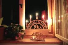 Ein Schwibbogen mit der Aufschrift Refugees Welcome steht beleuchtet im Fenster