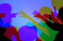 Bunte Schatten spielen mit ihren Händen.