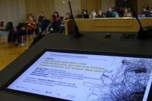 Blick auf den Screen am Redner*innenpult. Hier wird das Podium angekündigt.