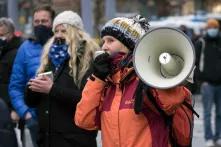 Eine Frau auf einer Demo von Corona-Leugner:innen spricht in ein Megafon
