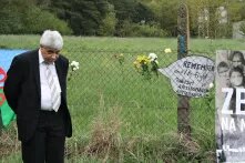 Ein Mann steht am Zaun.