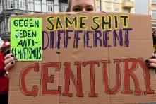 Eine Frau trägt in selbstgebasteltest Schild mit der Aufschrift: Same Shit, Different Century – gegen jeden Antisemitismus