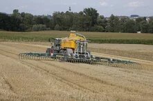 Traktor mit Güllewagen düngt ein Feld