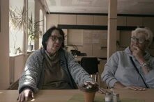 Am Tisch im Speisesaal an einem Vierertisch. Beide Frauen sitzen nebeneinander und sind im Gespräch.